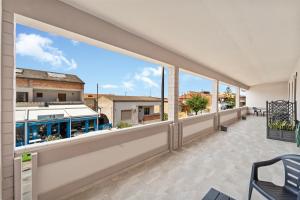 an empty balcony with large windows in a building at CLASS ROOMS AFFITTACAMERE con bagno privato , vicino alle DUNE di PORTO PINO in SantʼAnna Arresi