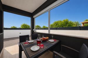 a table on a balcony with glasses of wine at Apartments ROSINI, 300m from the beach with shared tavern and bikes, Nin in Nin