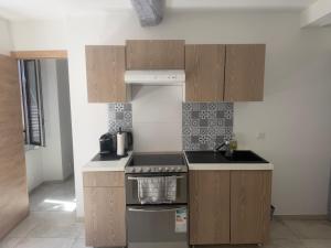 a kitchen with wooden cabinets and a stove top oven at Appartement La Colle sur Loup in La Colle-sur-Loup