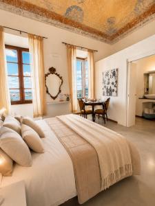 a bedroom with a large bed and a table at Palazzo Bolasco in Alghero