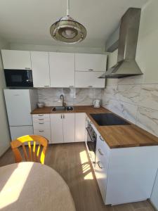 a kitchen with white cabinets and a counter top at Vila Varėna in Varėna
