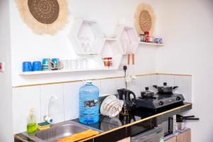 a kitchen with a sink and a stove at Angie's Cozy Studio Diani Beach in Ukunda