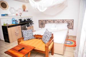 a kitchen with a table and two chairs in a room at Angie's Cozy Studio Diani Beach in Ukunda