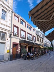 a building with tables and chairs on a street at Apartments ABC in Mostar