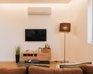 a living room with a flat screen tv on the wall at Lourença Stays - Quinta Lourença in Vilar