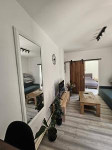a living room with a mirror and a table at Apartman ANTEO in Slavonski Brod