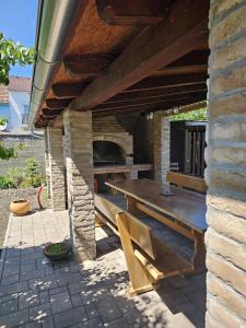 a patio with a wooden table and a pizza oven at Apartman ANTEO in Slavonski Brod
