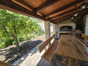 a picnic table under a roof with a pizza oven at Apartman ANTEO in Slavonski Brod