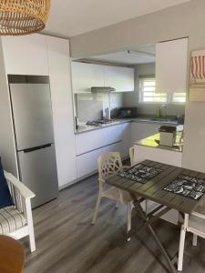 a kitchen with a table and chairs and a refrigerator at Spacious basement studio in tranquil nook in Rivière Noire