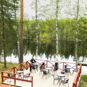 people sitting at tables on a wooden bridge near a lake at Kyyrönkaita in Kyyrö