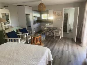 a kitchen and living room with a table and chairs at Spacious basement studio in tranquil nook in Rivière Noire
