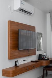 a flat screen tv hanging on a wall at GermanHomesHotel in Thimi
