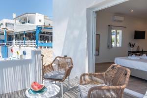 a room with a balcony with two chairs and a bed at Next to the wave in Myrties