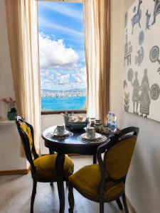 a table and two chairs in a room with a window at Palazzo Bolasco in Alghero