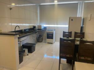 a large kitchen with a sink and a refrigerator at Apartamento Novo e ventilado in Petrolina