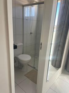 a bathroom with a toilet and a glass shower at Apartamento Novo e ventilado in Petrolina