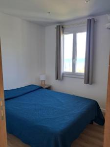 a bedroom with a blue bed and a window at Résidence de Tourisme Fior di Rena in Saint-Florent +61 photos