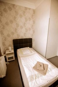a bedroom with a bed with a hat on it at Hotel Ratsstuben Kalbe in Kalbe +26 photos