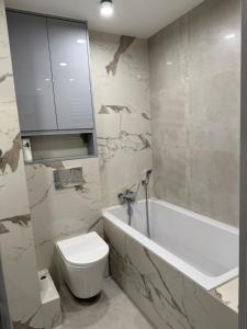 a bathroom with a toilet and a tub and a sink at Urban Relax AC Progres in Toruń