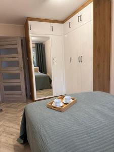 a bedroom with a bed and a tray with bowls on it at Urban Relax AC Progres in Toruń