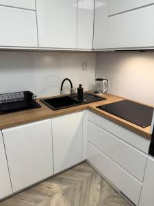 a kitchen with white cabinets and a sink at Urban Relax AC Progres in Toruń