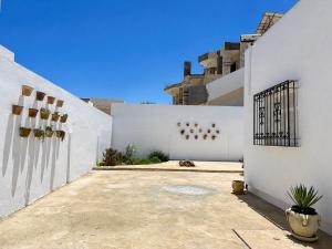 a white building with a courtyard with a fence at Dar almasyaf, maison bord de mer in Gabès