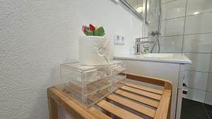 a vase with a flower in it sitting on a table in a bathroom at Schwarzwald Lodge Schonach in Schonach