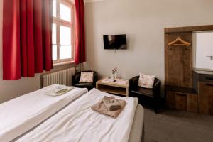 a hotel room with a bed and two chairs at Hotel Ratsstuben Kalbe in Kalbe