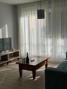 a living room with a table in front of a window at Apartments ABC in Mostar