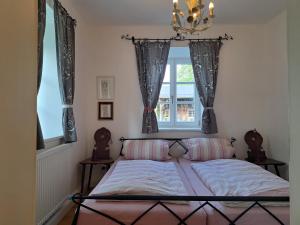 a bedroom with a bed with a window and a chandelier at Ferienwohnungen im Lüftlmalereck, Mussldomahaus in Oberammergau