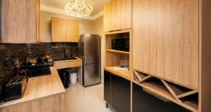 a kitchen with wooden cabinets and a stainless steel refrigerator at Bryanston Palms Accommodation in Johannesburg