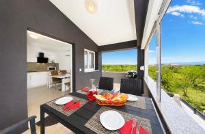 a dining room with a table with a bowl of fruit on it at Apartments ROSINI, 300m from the beach with shared tavern and bikes, Nin in Nin +42 photos