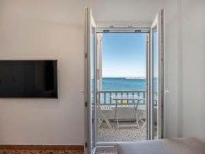 a room with a sliding glass door with a view of the ocean at Paroikia Sunset in Kampos Paros