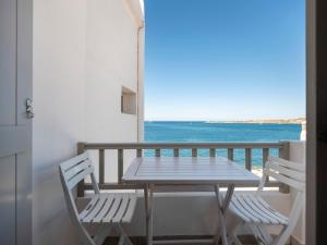 a table and chairs on a balcony with the ocean at Paroikia Sunset in Kampos Paros