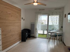 a living room with a sliding door and a table with chairs at Studio 25m2 à deux pas des thermes in Balaruc-les-Bains