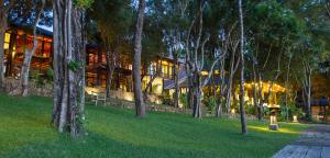 a building with a lot of trees in front of it at The Deer Park Hotel in Giritale