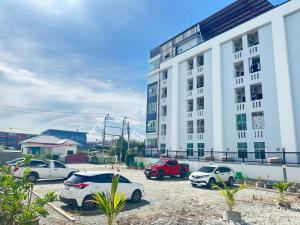 a group of cars parked in a parking lot in front of a building at At Ease Hotel Suvarnabhumi in Bang Phli