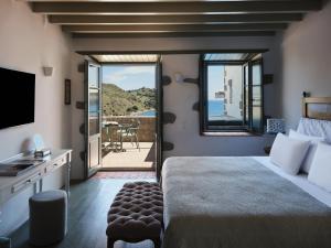a bedroom with a bed and a view of the ocean at Patmos Eye Boutique Hotel & Villas in Skala