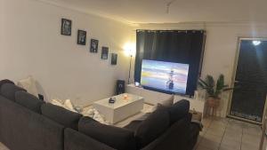 a living room with a couch and a flat screen tv at Taking 5 in West Tamworth