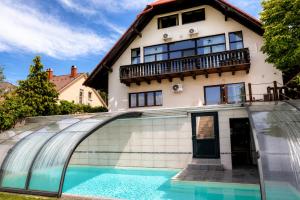 a house with a swimming pool in front of it at Határtalan Vendégház in Pilisszentiván