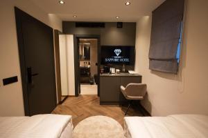 a bedroom with a bed and a table and a chair at Sapphire Hotel in Prizren
