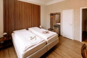 a bedroom with a large white bed in a room at Hotel Ratsstuben Kalbe in Kalbe