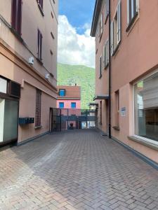 an empty alley between two buildings with mountains in the background at Fortezza in Bellinzona