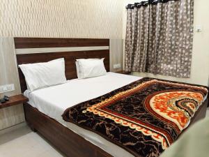 a bedroom with a bed with a blanket on it at HoTEL SRI DURGA GRAND in Vijayawāda