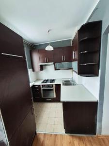 a kitchen with brown cabinets and a white counter top at Jelitkowo Beach Apartment in Gdańsk