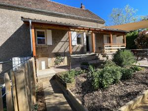 a house with a porch with a fence at La ferme Bourguignonne in Saizy