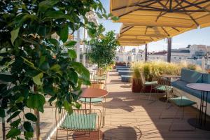a patio with tables and chairs and plants at Room Mate Oscar, Madrid in Madrid