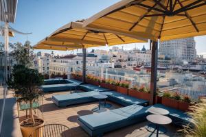 a rooftop patio with blue benches and umbrellas at Room Mate Oscar, Madrid in Madrid