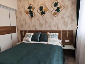 a bedroom with a large green bed with pillows at Rubin Verde Residence in Sárvár +14 photos
