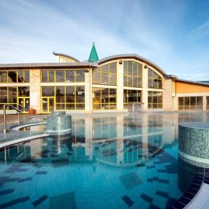 a large building with a pool in front of it at Rubin Verde Residence in Sárvár